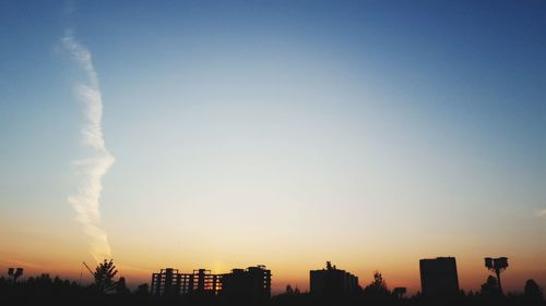 Silhouette buildings against sky during sunset