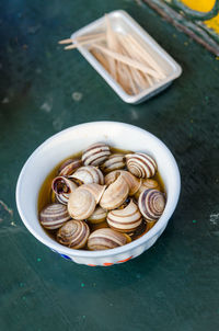 High angle view of boiled snails in bowl on table