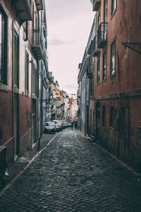 Street amidst houses against sky in city