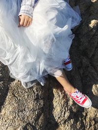 Low section of woman sitting on rock