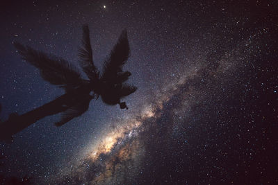 Low angle view of woman standing against star field