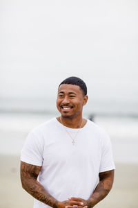 Mixed race man smiling at beach