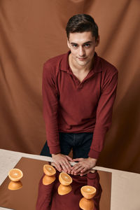 Portrait of young man sitting on table