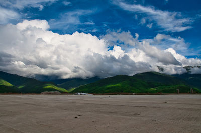 Scenic view of road by mountains against sky