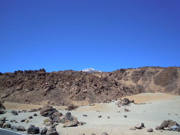 Scenic view of desert against clear blue sky