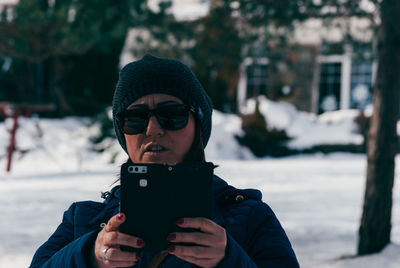 Close-up of woman using mobile phone during winter