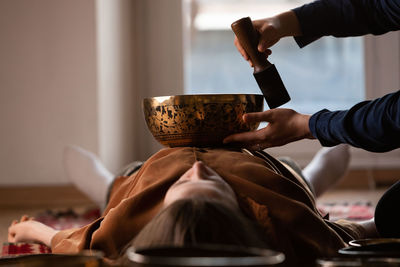 Woman making relaxing massage, meditation, sound therapy with tibetian singing bowls. 