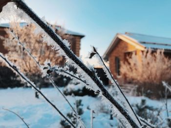 Close-up of frozen house against sky during winter