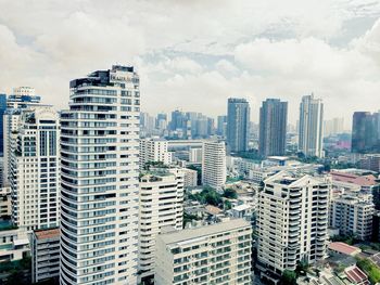 View of cityscape against cloudy sky