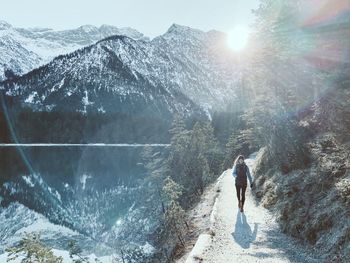 Full length of woman walking on mountain road during winter