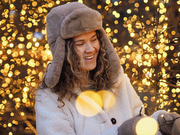 Portrait of young woman holding christmas tree