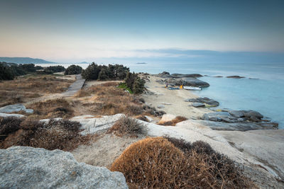 Rocks on sea shore against sky