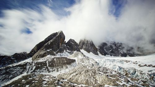 Low angle view of snowcapped mountain against sky