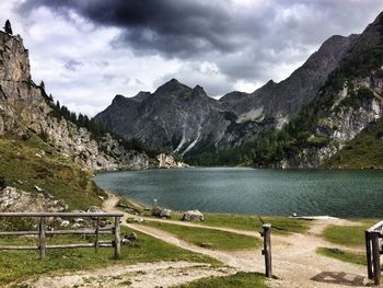 Scenic view of lake by mountains against sky