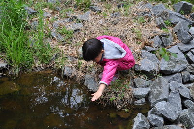 High angle view of cute girl playing at pond