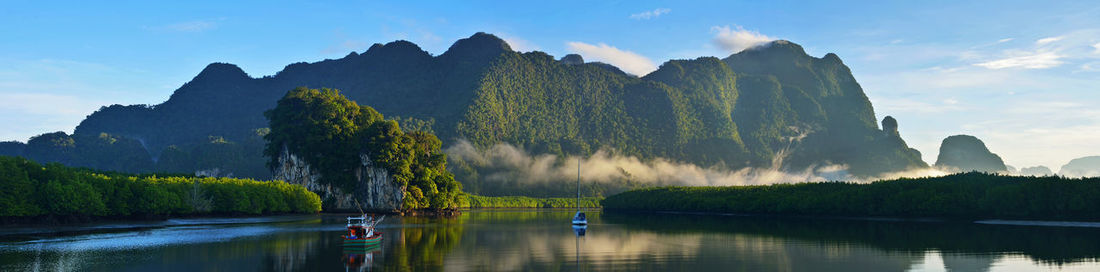 Panoramic view of lake and trees against sky