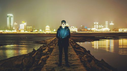 Woman standing in illuminated city at night