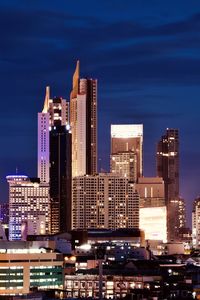 Modern buildings against blue sky at night
