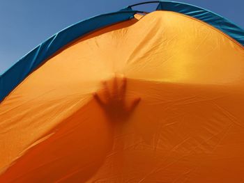 Shadow of woman holding yellow umbrella