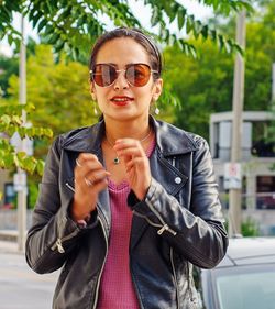 Portrait of young woman wearing sunglasses standing outdoors