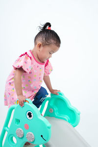 Boy playing with toy against white background