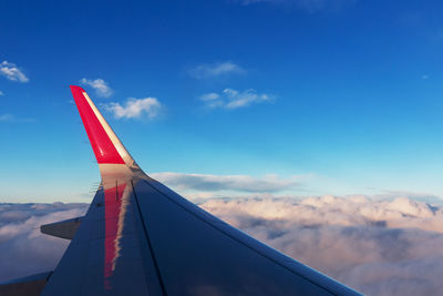 Cropped image of aircraft wing flying against sky