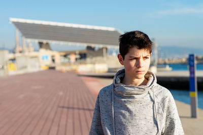 Close-up of teenage boy looking away on city promenade