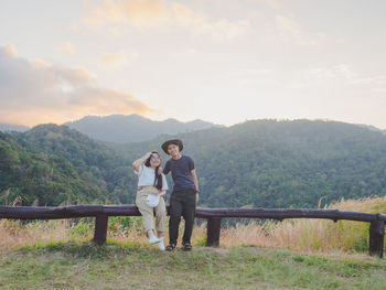 Rear view of woman standing on field against mountain