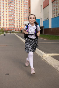 Back to school. girl in school uniform go to school with backpack behind their backs. beginning