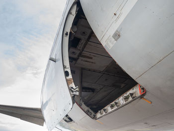 Low angle view of airplane against cloudy sky