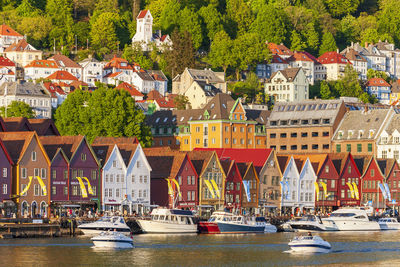 Boats in river by buildings in city