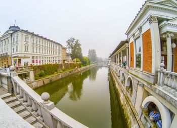 Canal amidst buildings against sky