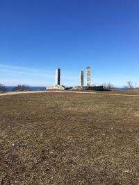 Tower on field against clear blue sky