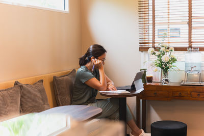 Young woman using laptop at home