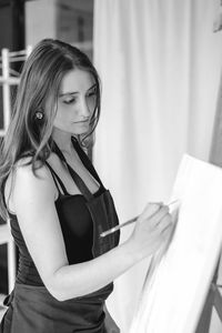 Beautiful woman painting at home