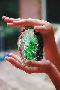 Close-up of hand holding glass decoration