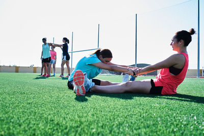 Group of young women practice stretching after their training