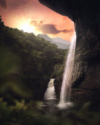 Scenic view of waterfall against sky