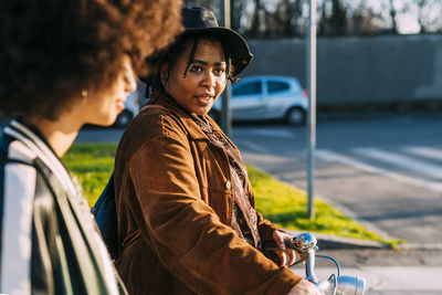 Side view of young woman standing in car