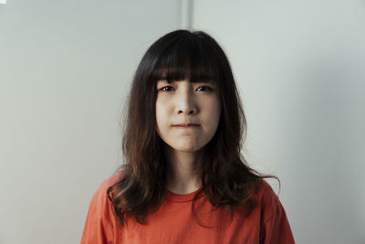 Portrait of young woman against white background