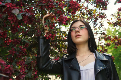 Portrait of woman standing against plants