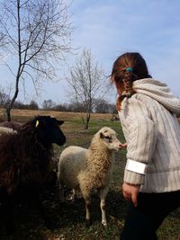 Woman touching sheep field