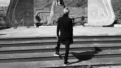 Rear view of man walking on staircase