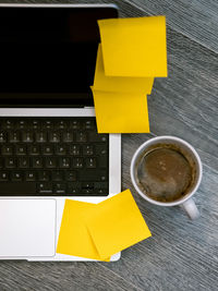 High angle view of coffee and laptop on table