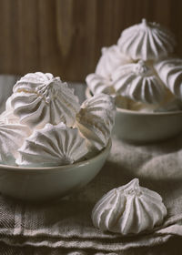 High angle view of meringues in bowls on fabric