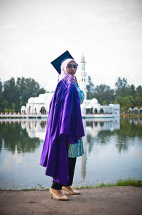 Woman standing by lake against sky