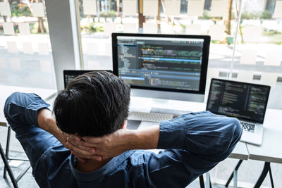 Rear view of man working in office