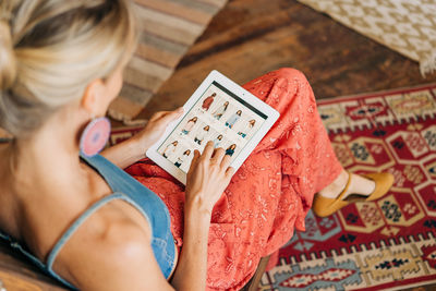 A woman uses an electronic tablet to search the website and order clothes for delivery.