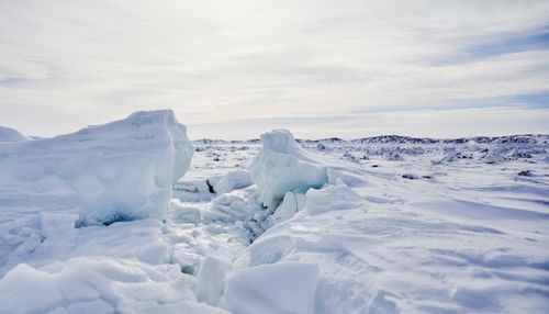 Snow covered landscape against sky