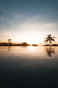 Scenic view of lake against sky at sunset